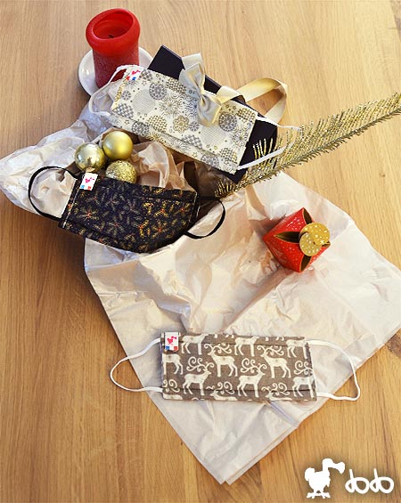 Choisissez Abcskate pour un Noël haut en couleurs ! Masques Abcskate mis en scène avec une bougie, des boules de Noël et du papier de soie
