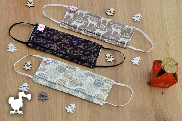 3 masques Abcskate entourés de petits sapins en bois