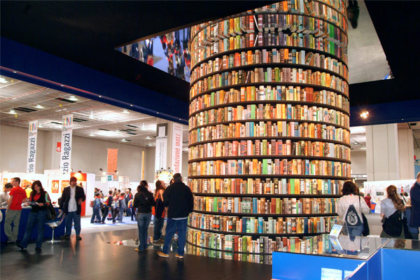 Photo d'une grande tour de livres au milieu d'une pièce