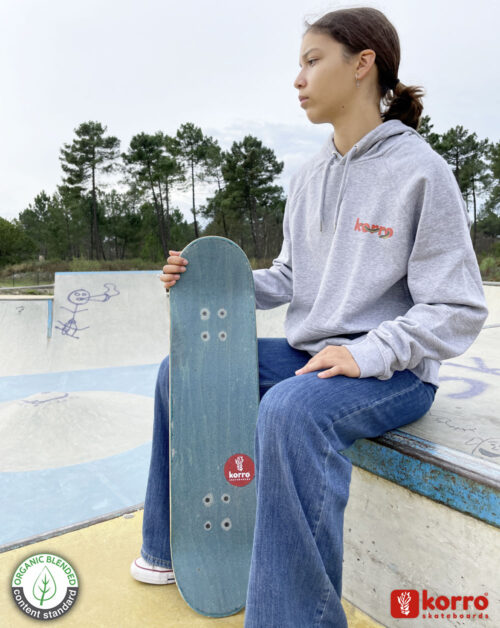 Sweatshirt gris "Golden Skull" porté par une jeune fille avec sa planche de skate