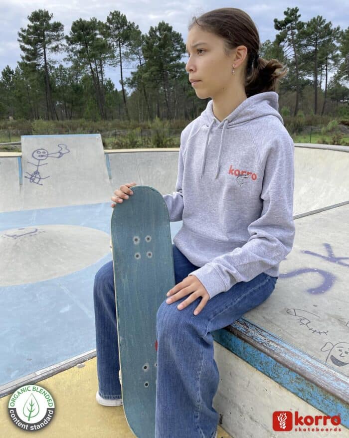 Sweatshirt gris "Love Shark" porté par une jeune fille avec sa planche de skate